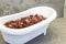 Flowers potpourri in white bathtub