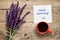 Flowers of salvia, coffee cup and paper with Good morning text on table