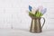 Flowers tulips made of cloth in a metal vase pitcher. White back