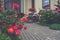 Flowers in vases at the entrance to a country house, town house. Entrance door with stairs decorated with blooming