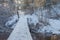 Flowing forest river and snow-covered concrete bridge on a beautiful winter day