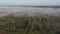 Flowing mist above morning landscape with forest and road, aerial