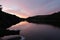 Flowing river reservoir with small waterfall at sunset.Peak district. Derwent Valley.