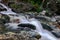 flowing soft torrent in rocky mountains near a waterfall