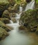 Flowing water among boulders and rocks below Japanese waterfall