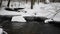 Flowing Water In Park with Snow. Icicle in Background.