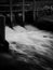 Flowing water, wooden bridge and wild rose at irrigation dam