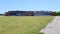 Floyd Bennett Field, grass covered lawn, abandoned hangar with Art Deco elements in the background, New York, NY, USA