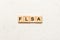 FLSA word written on wood block. Fair Labor Standards Act text on table, concept