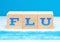 Flu concept. The word blue, located on wooden cubes on a background of a medical mask