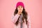 Flu season. Sneezing. Cold climate weather. Little girl sick ill pink background. Kid puffer jacket and knitted hat