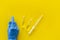 Flu vaccination. Ampoule, syringe, medic`s hand on yellow background top view copy space
