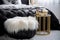 Fluffy bedside ottoman in a luxurious glamorous interior with gold and black decor