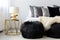 Fluffy bedside ottoman in a luxurious glamorous interior with gold and black decor