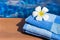 Fluffy blue towel with plumeria frangipani flower on border of a swimming pool