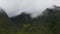 Fluffy clouds on a cloudy day float past the tops of the mountains. A summer trip to Altay. Hiking in the mountains of Russia