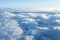 Fluffy clouds seen from above from the airplane window. .Climatology and weather concept