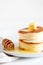 Fluffy Japan souffle pancakes, hotcakes with butter and maple syrup or honey sauces on light white background