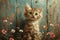 Fluffy kitten with captivating eyes in front of a painted floral background.