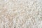 Fluffy long pile soft woolen light beige carpet above view macro