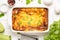Fluffy omelet baked with zucchini, kids healthy Breakfast, tasty casserole. On white wooden background, in baking dish
