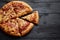 Fluffy pepperoni pizza in american style placed on rusty old black wooden table