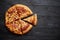 Fluffy pepperoni pizza in american style placed on rusty old black wooden table