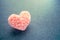 Fluffy pink thread heart on gray felt background. Handmade pretty heart. Love, romance, Valentines day DIY concept. Selective