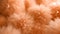 Fluffy soft peach fuzz color pompoms closeup macro shot background with a delicate furry texture. Modern trendy tone hue shade