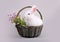 Fluffy white bunny in a basket with flowers