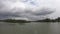 Fluffy white clouds above lake in topical country. Cloudscape in soft blue sky in bright nature background in rainy season.