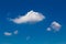 Fluffy white clouds against deep blue sky