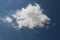 Fluffy white cumulus fractus cloud in a blue summer sky