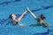 Fluid grace and synchronized beauty of a female duet, dancing in perfect harmony in the mesmerizing aquatic ballet of synchronized