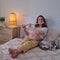 Flute in the hands of a pregnant woman on a home bed, rest and learning musical instruments of the expectant mother