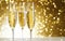 flutes with champagne or fizzy white wine on black background with blurred sparkles in the back