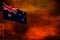 Fluttering Australia flag mockup with blank space for your text on crimson red sky with smoke pillars background. Troubles concept