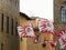 Fluttering flags in Volterra village during historic flag throwing competition . Tuscany, Italy