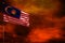 Fluttering Malaysia flag mockup with blank space for your text on crimson red sky with smoke pillars background. Troubles concept