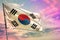 Fluttering Republic of Korea South Korea flag on colorful cloudy sky background. Prosperity concept