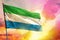 Fluttering Sierra Leone flag on beautiful colorful sunset or sunrise background. Success concept