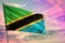 Fluttering Tanzania flag on colorful cloudy sky background. Prosperity concept