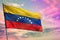 Fluttering Venezuela flag on colorful cloudy sky background. Prosperity concept