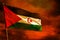 Fluttering Western Sahara flag on crimson red sky with smoke pillars background. Troubles concept