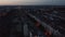 Fly above blocks of residential buildings. Tilt up reveal view of city before sunrise. Colourful twilight sky. Berlin
