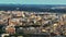 Fly above city. Aerial zoomed shot of apartment buildings in city centre lit by low sun. Rome, Italy