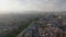 Fly above historic city quarter. Hazy view against sunshine at golden hour. Silhouette of TV tower on hill in background