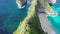 Fly by along the ridge with a pathway down to Kelingking Beach next to huge steep cliff, Nusa Penida, Bali, Indonesia