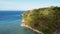 Fly around cliff and rocks over ocean along coast