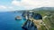 Fly around cliff and rocks over ocean along coast